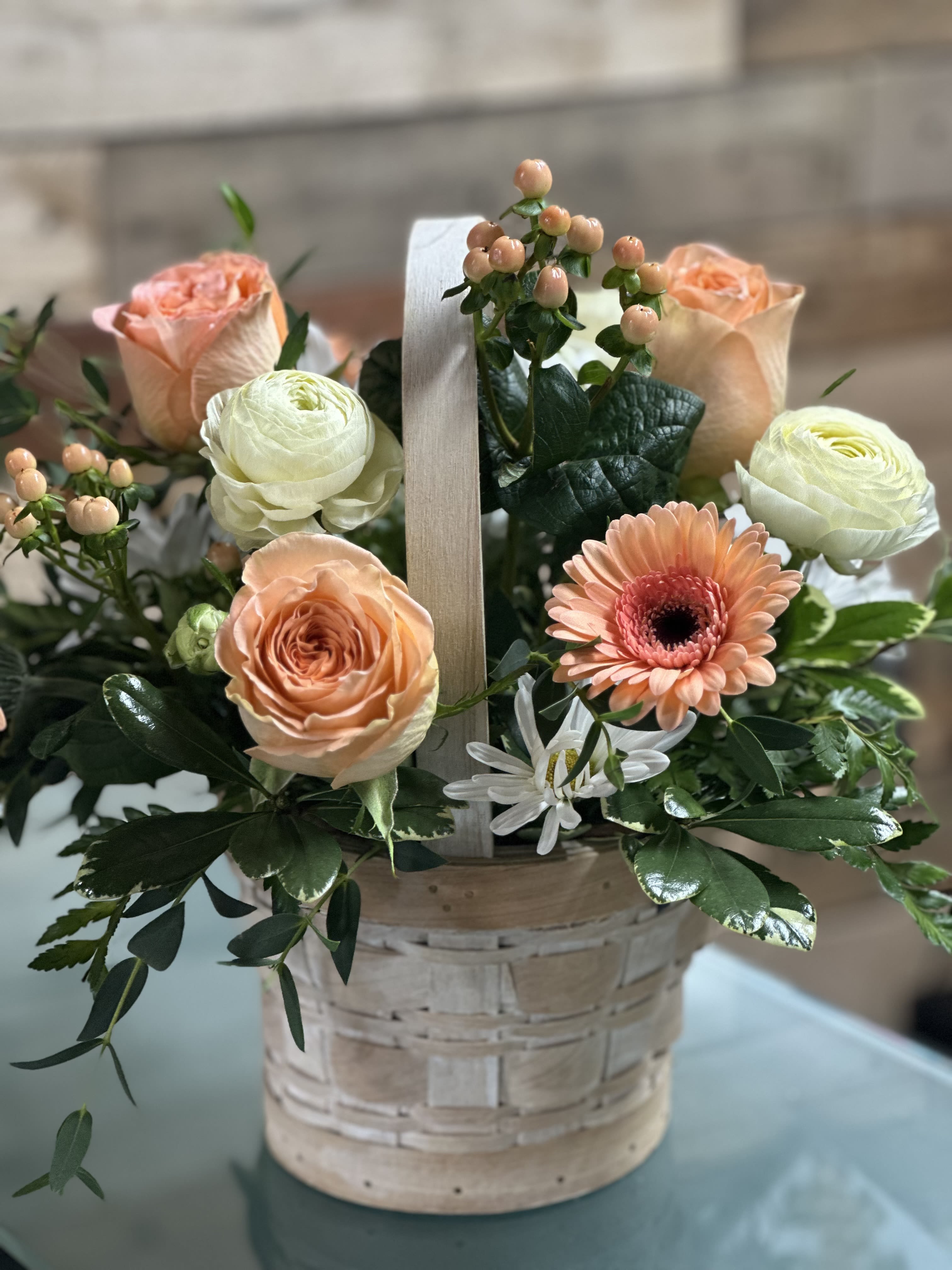 Basket of Blooms - One of our Mother's Day Special feature arrangements...Basket of Blooms is a charming mix of soft fresh blooms gathered in a basket.  This arrangement features a beautiful blend of roses, carnations, Gerbera daisies and berries thoughtfully designed for feel like a little garden in full bloom.  Color themes may vary depending on availability.