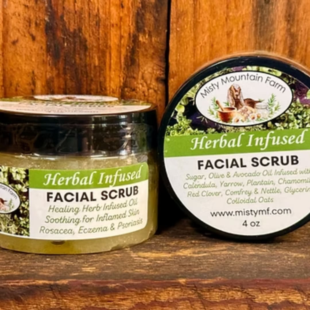 Two jars of herbal infused facial scrub on a wooden surface.