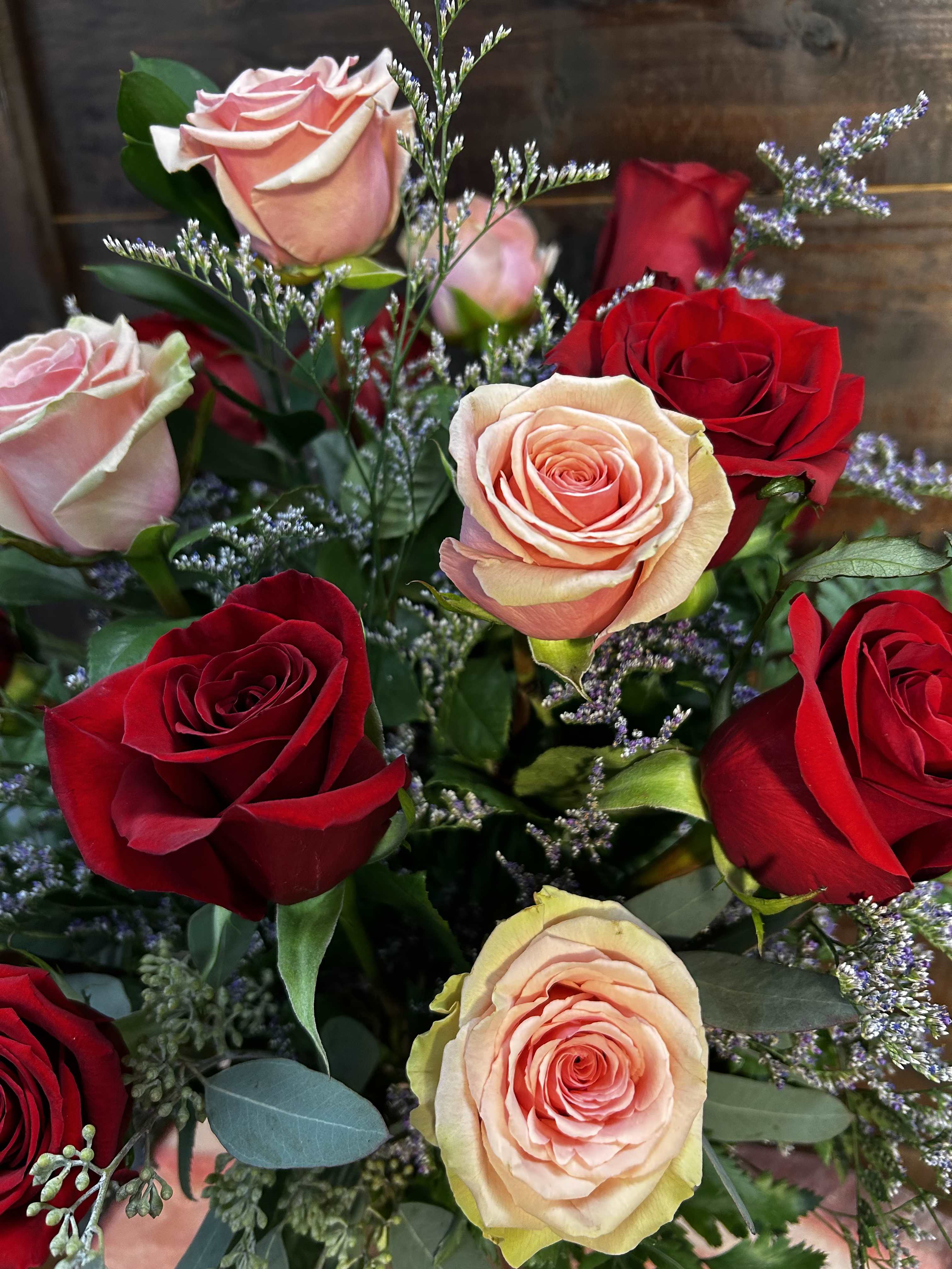 Bouquet of red and blush roses with small purple filler flowers