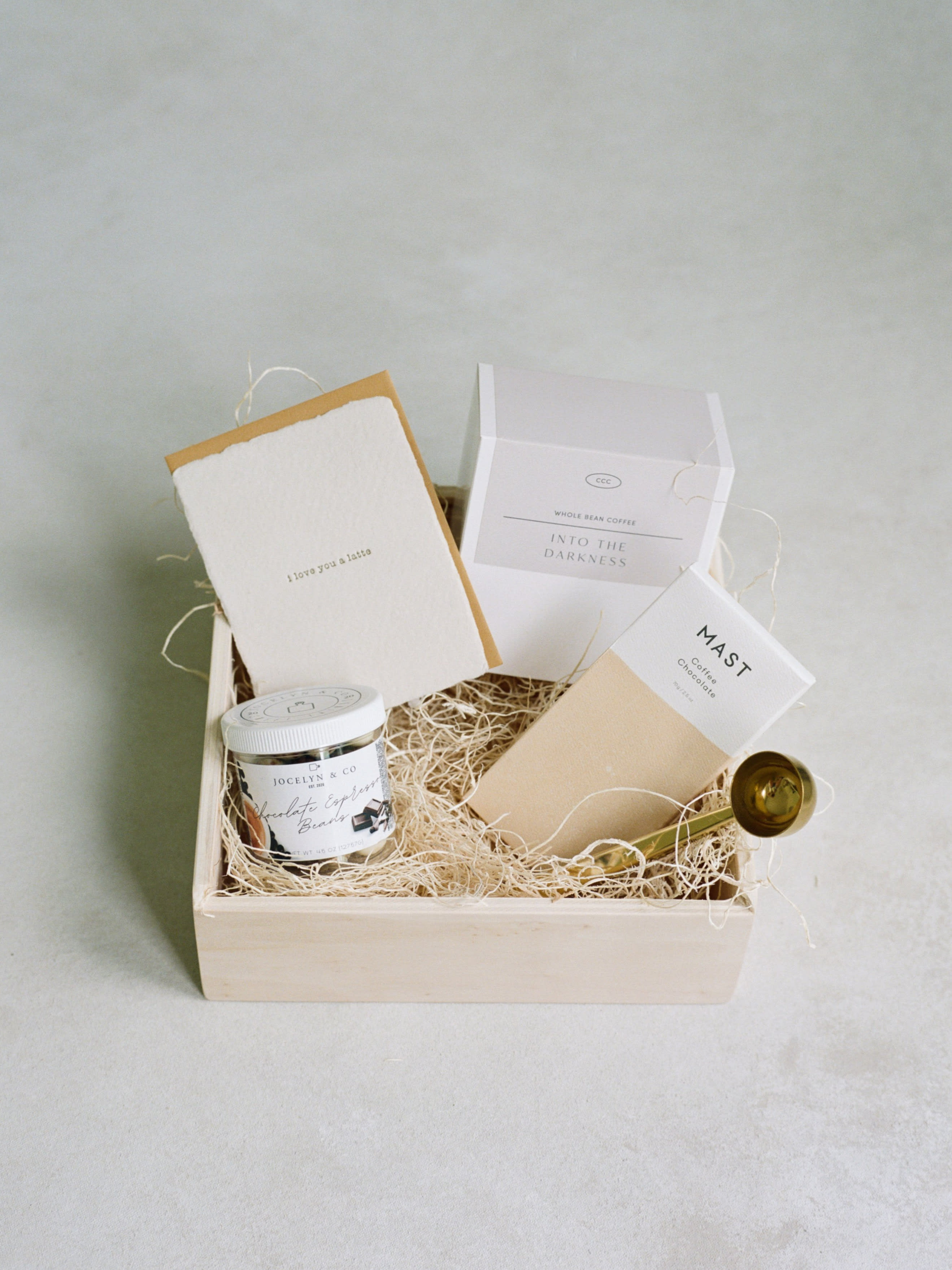 Gift box with coffee and chocolate items in a wooden tray