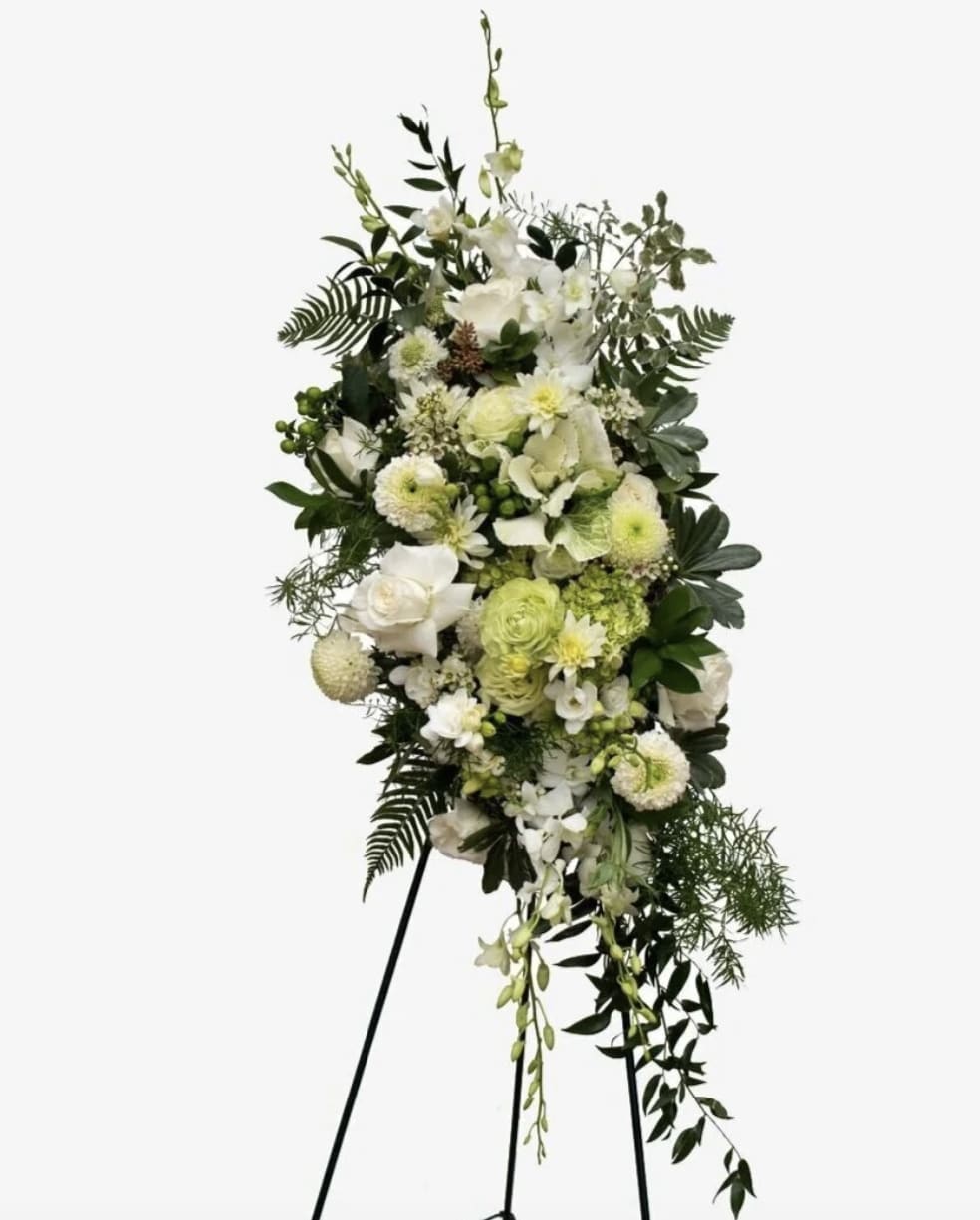 White Sympathy Spray  - An all white tribute, this funeral spray is pure and tranquil. Featuring a variety of white flowers and greenery.  PICTURED IS THE STANDARD SIZE. 
