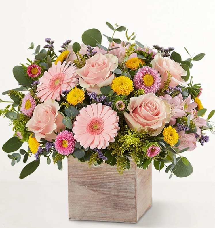 Pink roses and daisies arranged in a wooden box