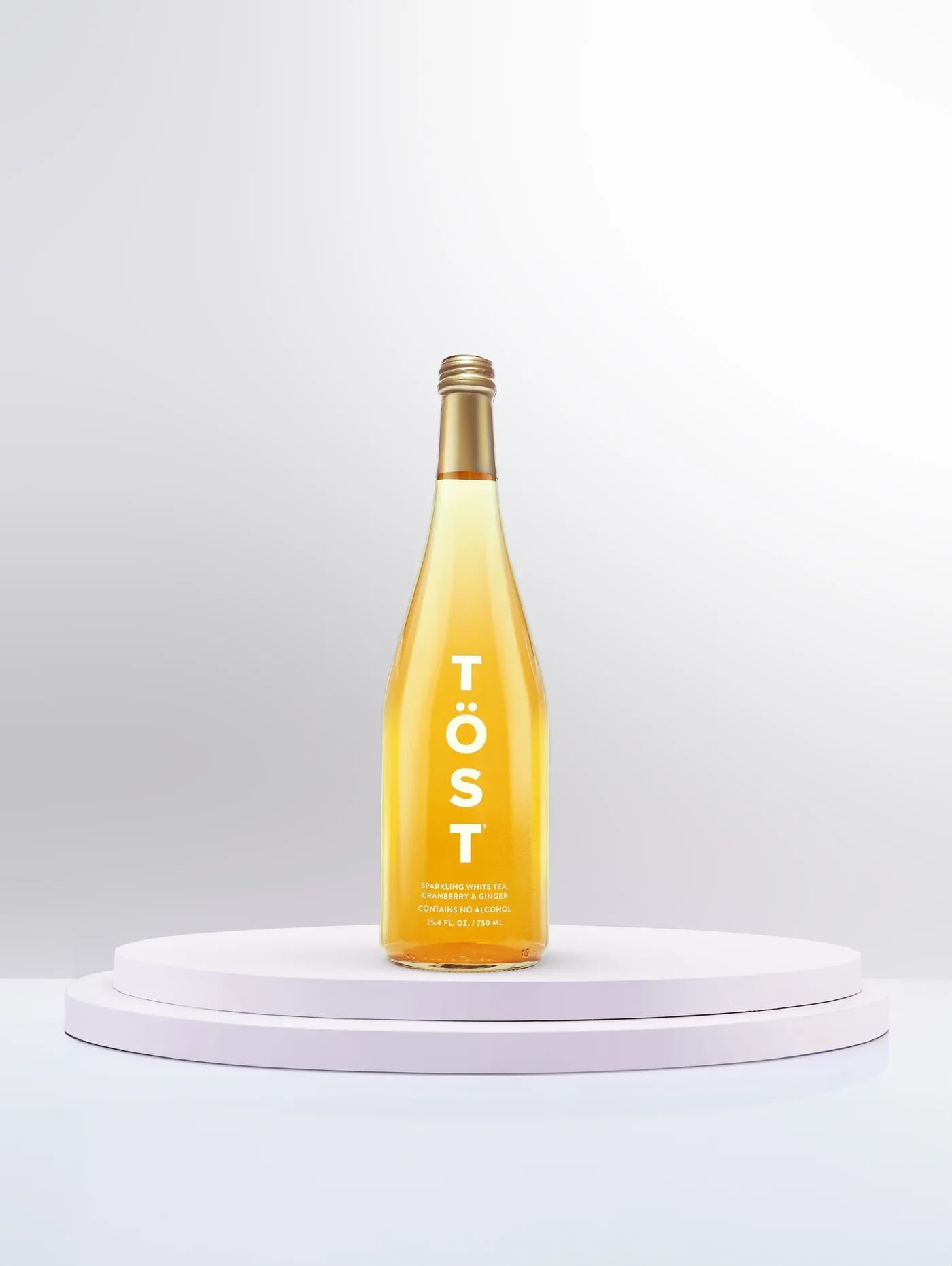 Bottle of sparkling white tea on a white pedestal