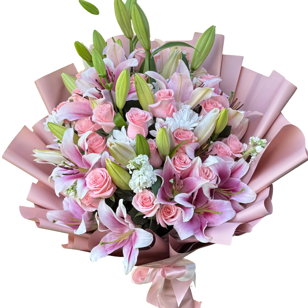 Pink lilies and roses wrapped in blush paper with a ribbon