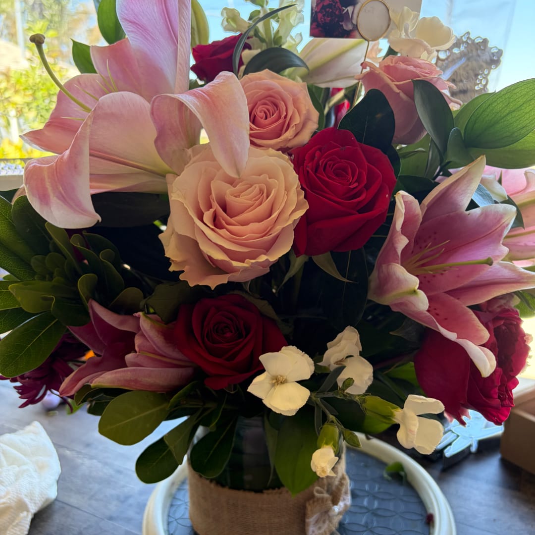 Bouquet of pink lilies and roses in a wrapped vase