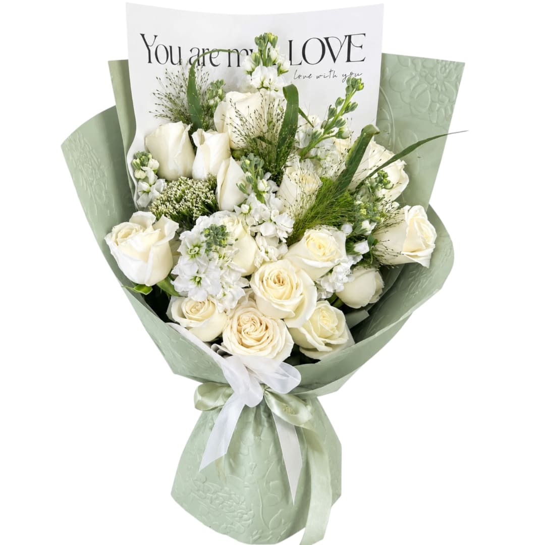 White rose bouquet wrapped in pale green paper with a ribbon