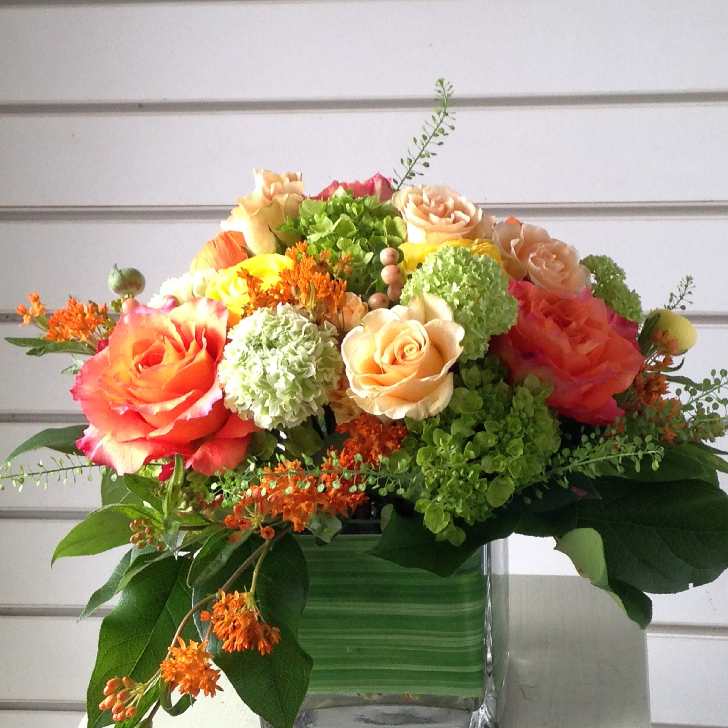 Mixed bouquet of roses and green hydrangeas in a glass vase