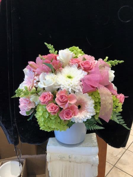Pink and white mixed flower arrangement in a white vase