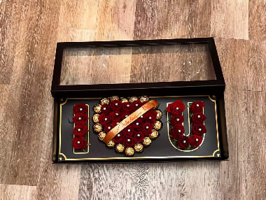 Boxed rose arrangement spelling I love you with chocolates