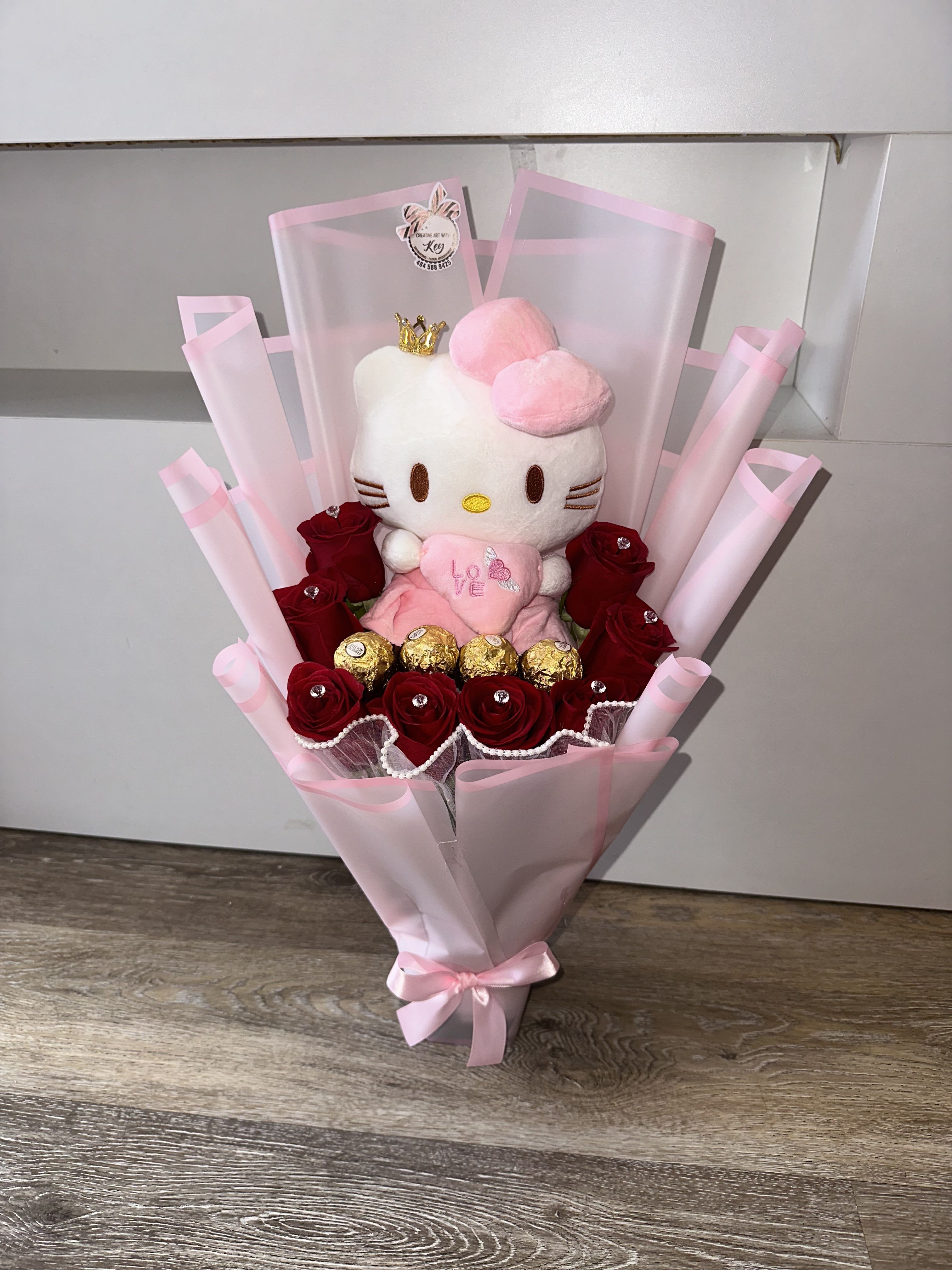 Bouquet of red roses with a Hello Kitty plush and gold chocolates in pink wrap