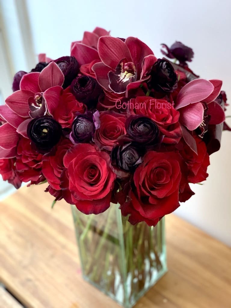 Red and burgundy bouquet in a clear glass vase