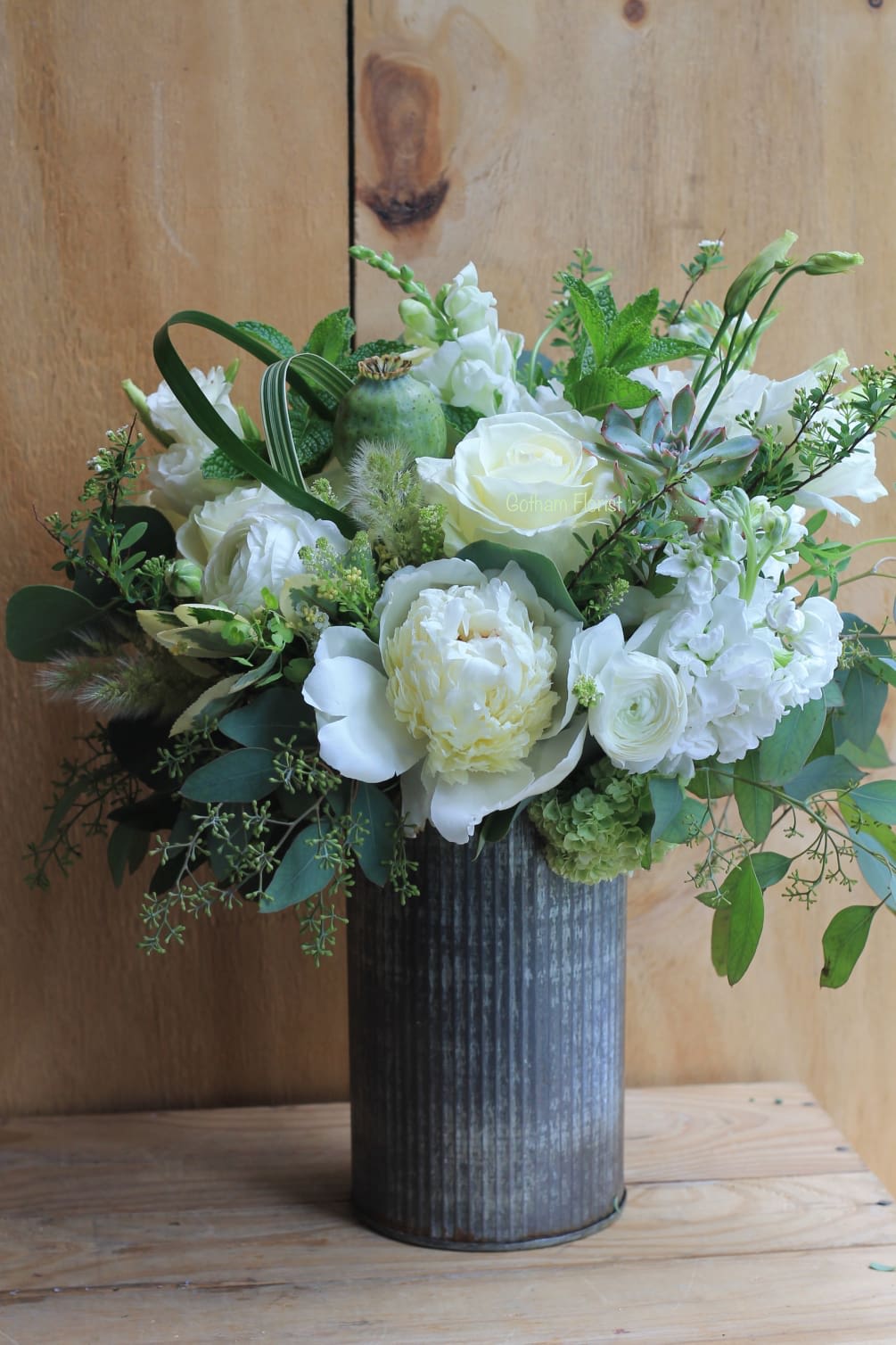 White floral arrangement in a dark ribbed vase