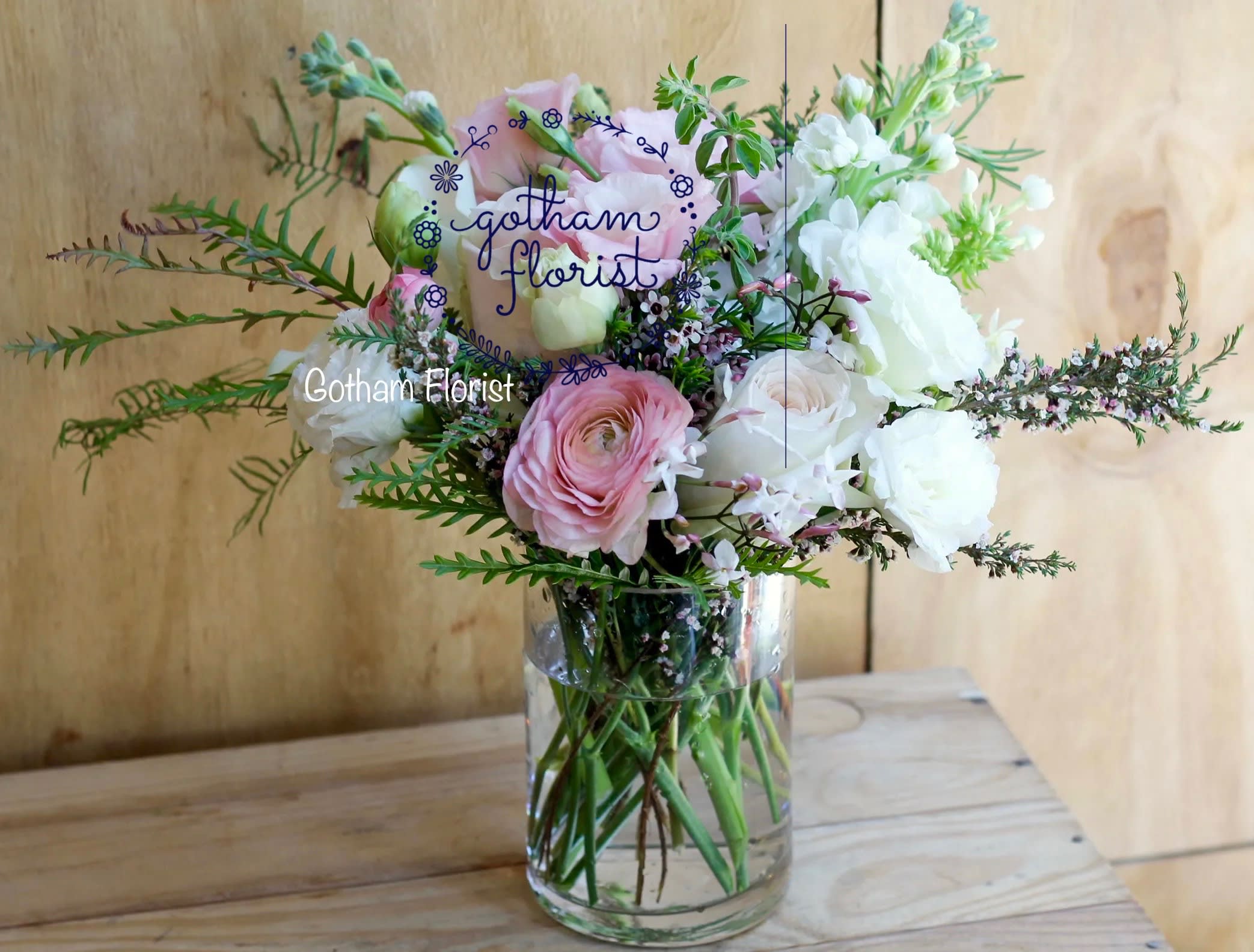 Pink and white flowers arranged in a clear glass vase