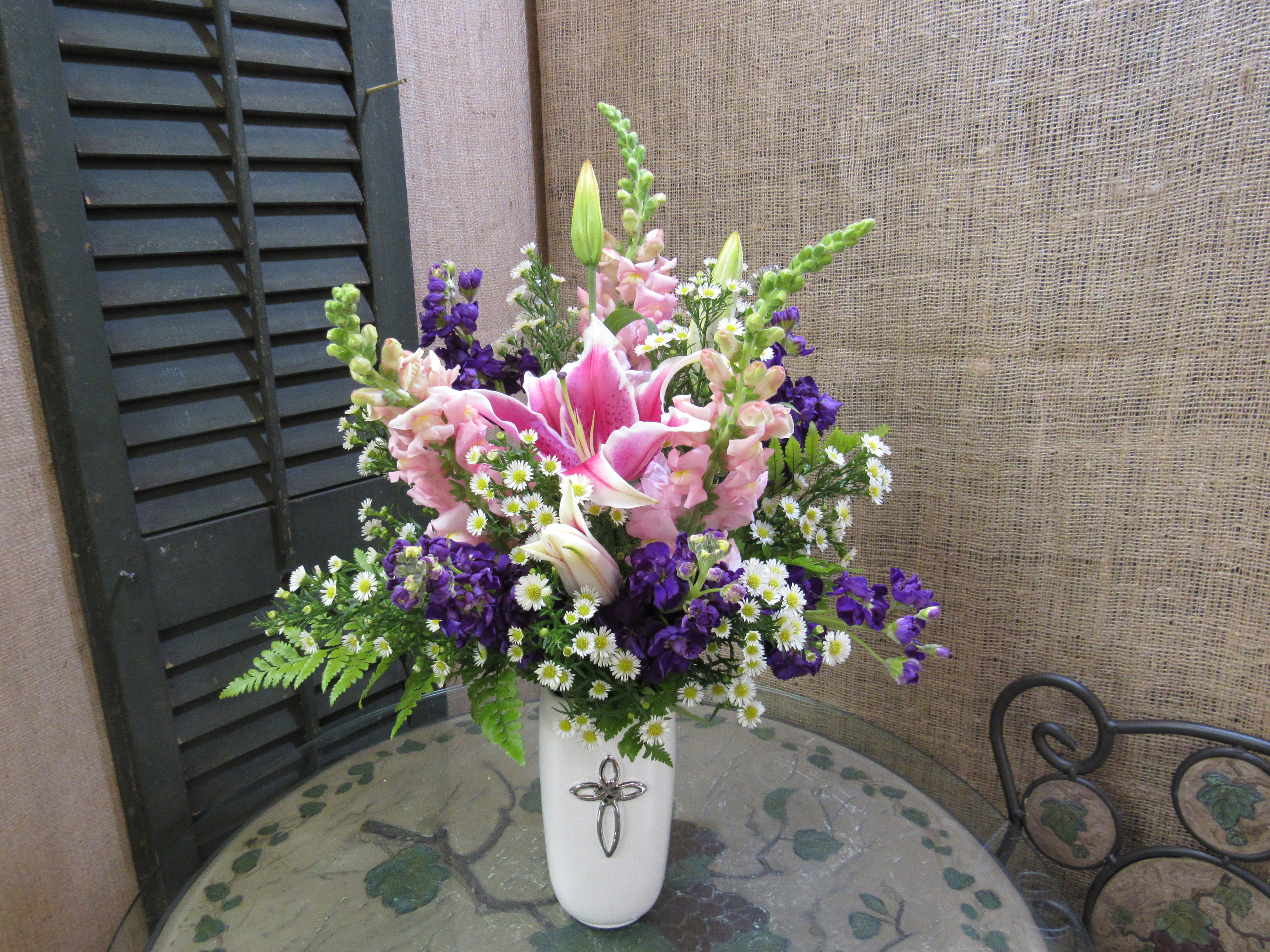 Pink lilies and purple flowers in a white vase