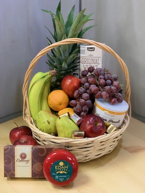 Fruit basket with bananas, grapes, apples, pears, pineapple, cheese, and chocolates