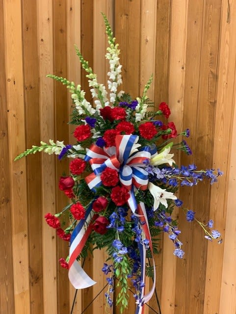 Tall red, white, and blue floral standing spray with ribbon