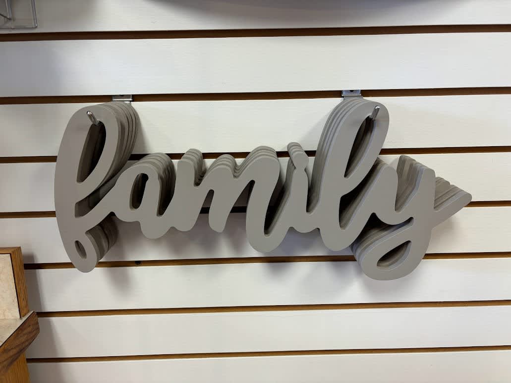 Gray layered wooden "family" wall sign on a slatwall display