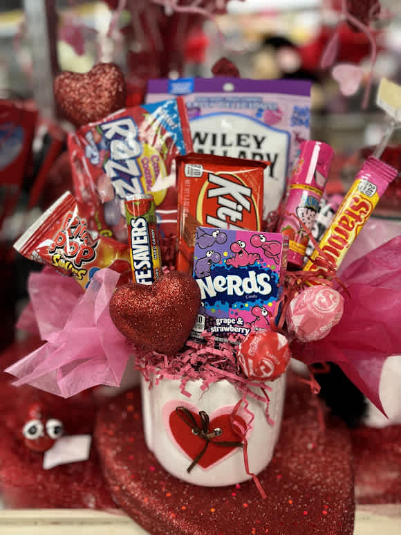 Candy bouquet in a white pot with pink tissue and heart decorations