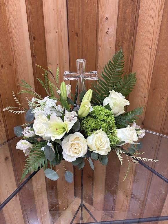 White floral arrangement with a clear cross centerpiece