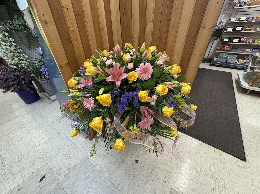 Large mixed bouquet with yellow roses, pink lilies, and purple accents