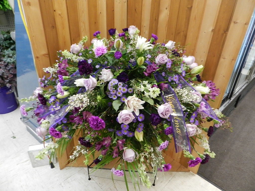 Large purple and white floral spray with ribbon accents