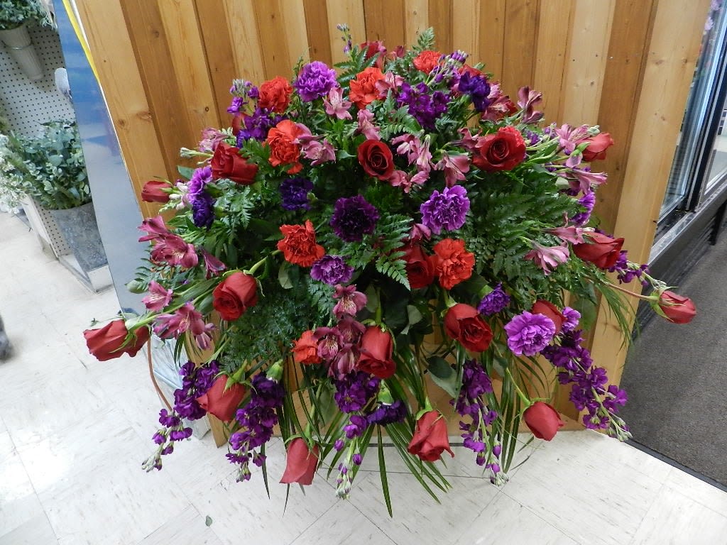 Large standing floral spray with red roses and purple flowers
