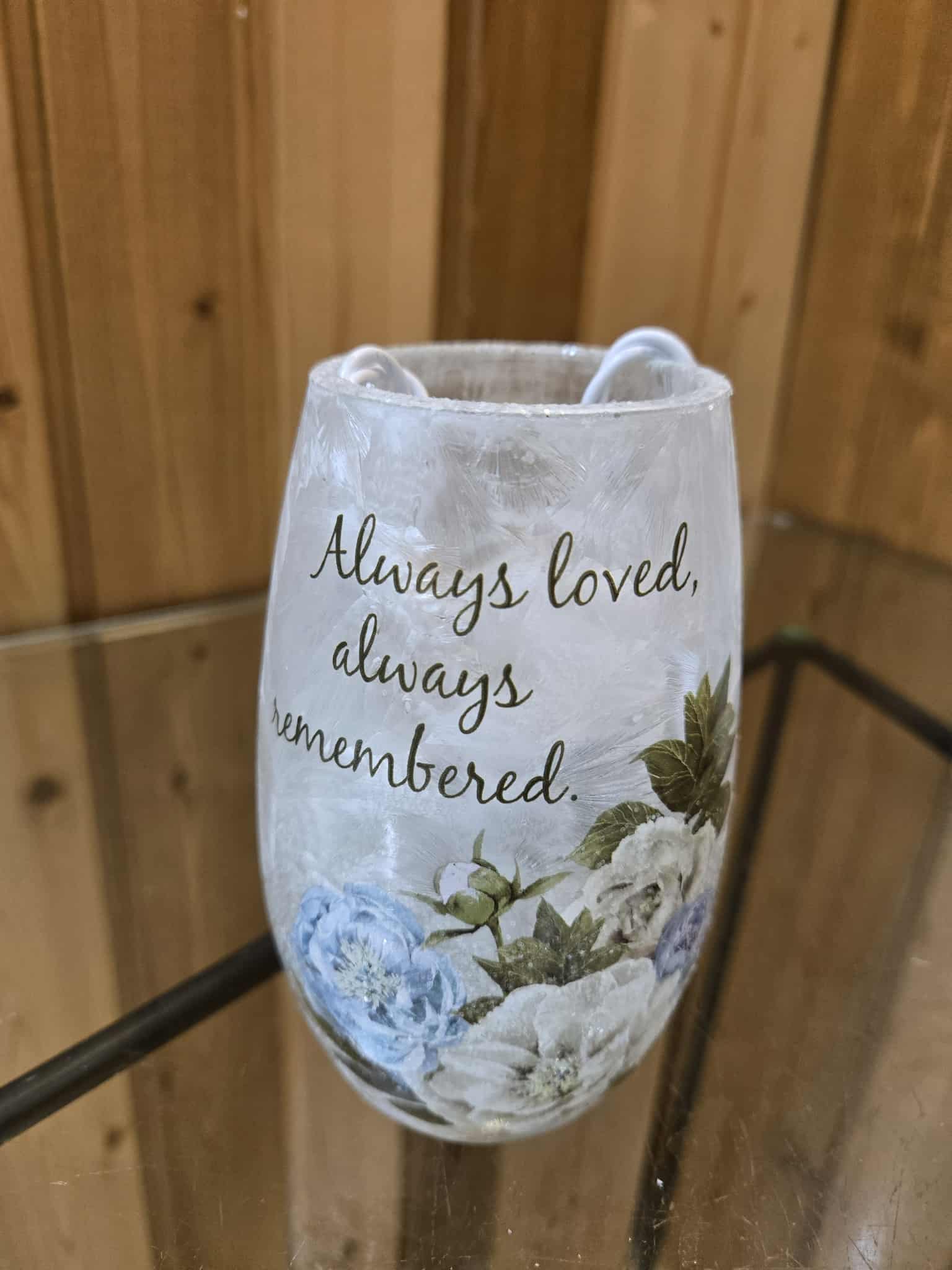 Decorative memorial candle holder with floral print and the words "Always loved, always remembered."