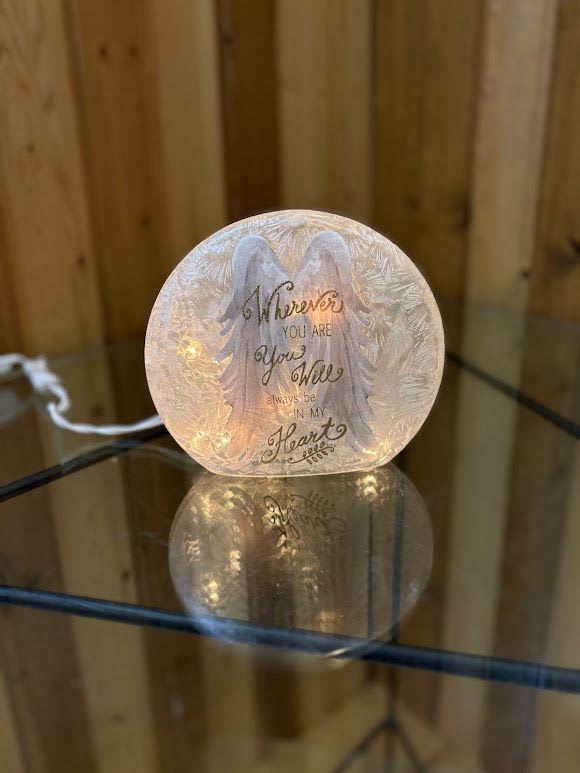 Glowing memorial light with angel wings and a sympathy message