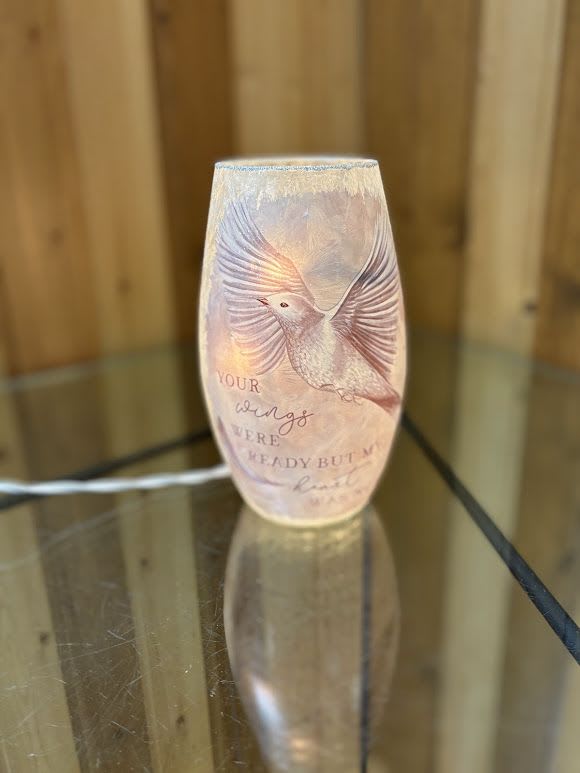Decorative glass candle holder with a bird design and printed text