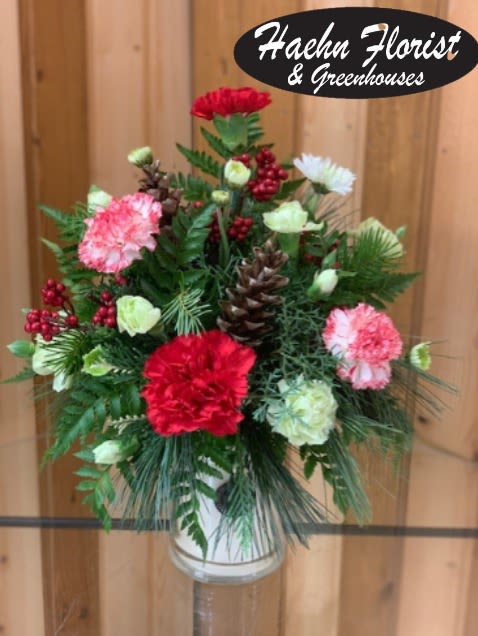 Candle Flower Arrangement - seasonal flowers  - Engraved Large Jar Candle with Optional Floral Arrangement – Haehn Florist &amp; Greenhouses  Send a unique gift that smells as wonderful as it looks! This large engraved jar candle is the perfect keepsake, burning for 145+ hours to fill any space with warmth and fragrance. Personalize your candle with a name, message, or special design—making it a one-of-a-kind gift for birthdays, anniversaries, memorials, or “just because.”  Please email the details you’d like engraved to haehnfloristlaser@gmail.com. Note: all engraving is completed before adding a flower arrangement.    Upgrade option: Choose the premium arrangement to have your candle beautifully displayed in a lush bed of fresh flowers—and this option includes a decorative lid. Standard engraved candles do not include a lid.   Available at: Haehn Florist &amp; Greenhouses 410 Hamilton Rd. Wapakoneta, OH 45895 ️ 419-738-8485  Give a gift that lasts long after the flowers fade—a fragrant, personalized candle that’s sure to be cherished.