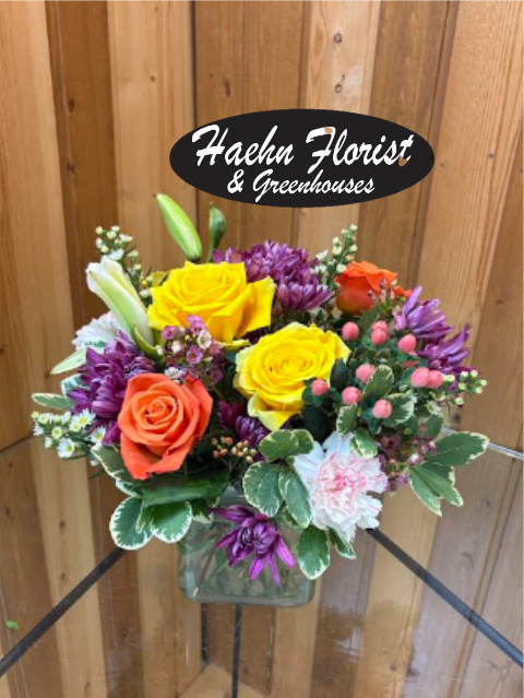 Mixed bouquet of yellow and orange roses in a glass vase