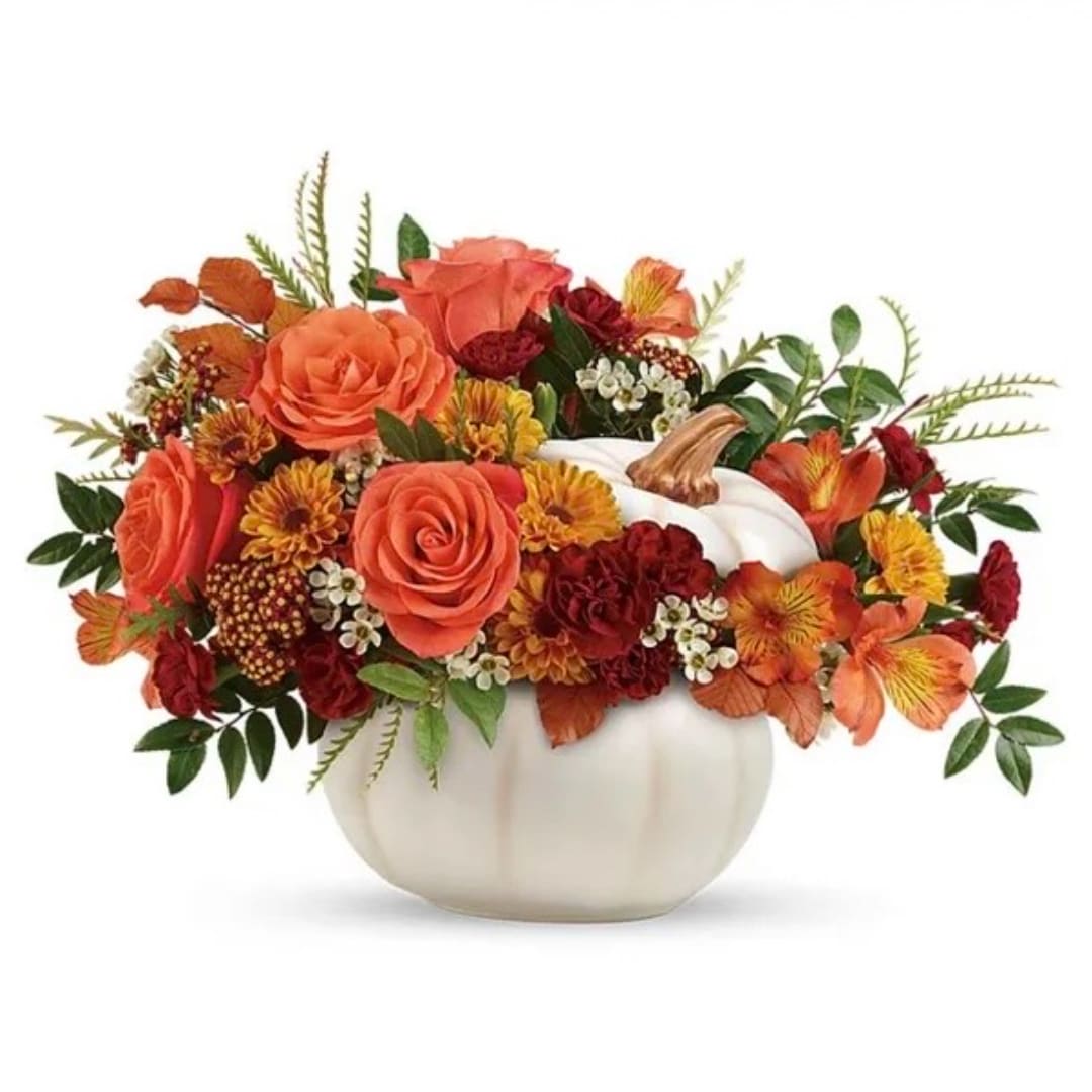 Orange and red floral arrangement in a white pumpkin-shaped vase