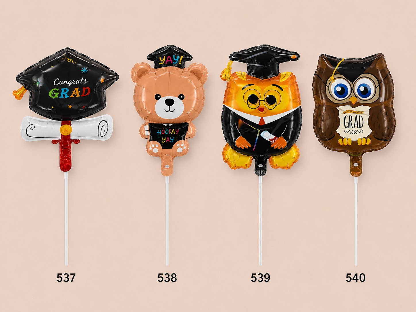 Four graduation-themed foil balloons shaped like a cap, bear, owl, and owl.