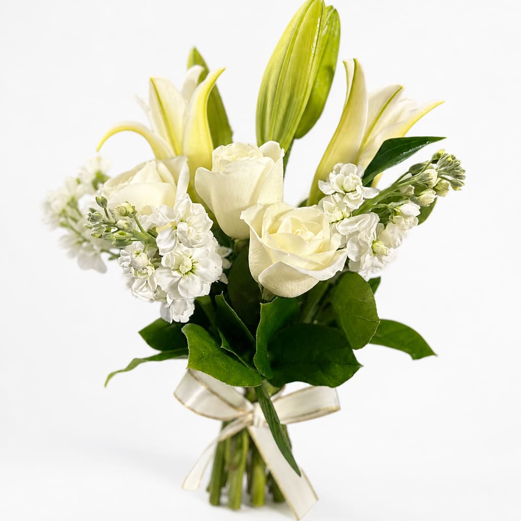 White roses and lilies arranged in a hand-tied bouquet with a ribbon