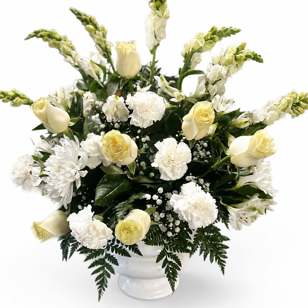 White and pale yellow flowers arranged in a white vase