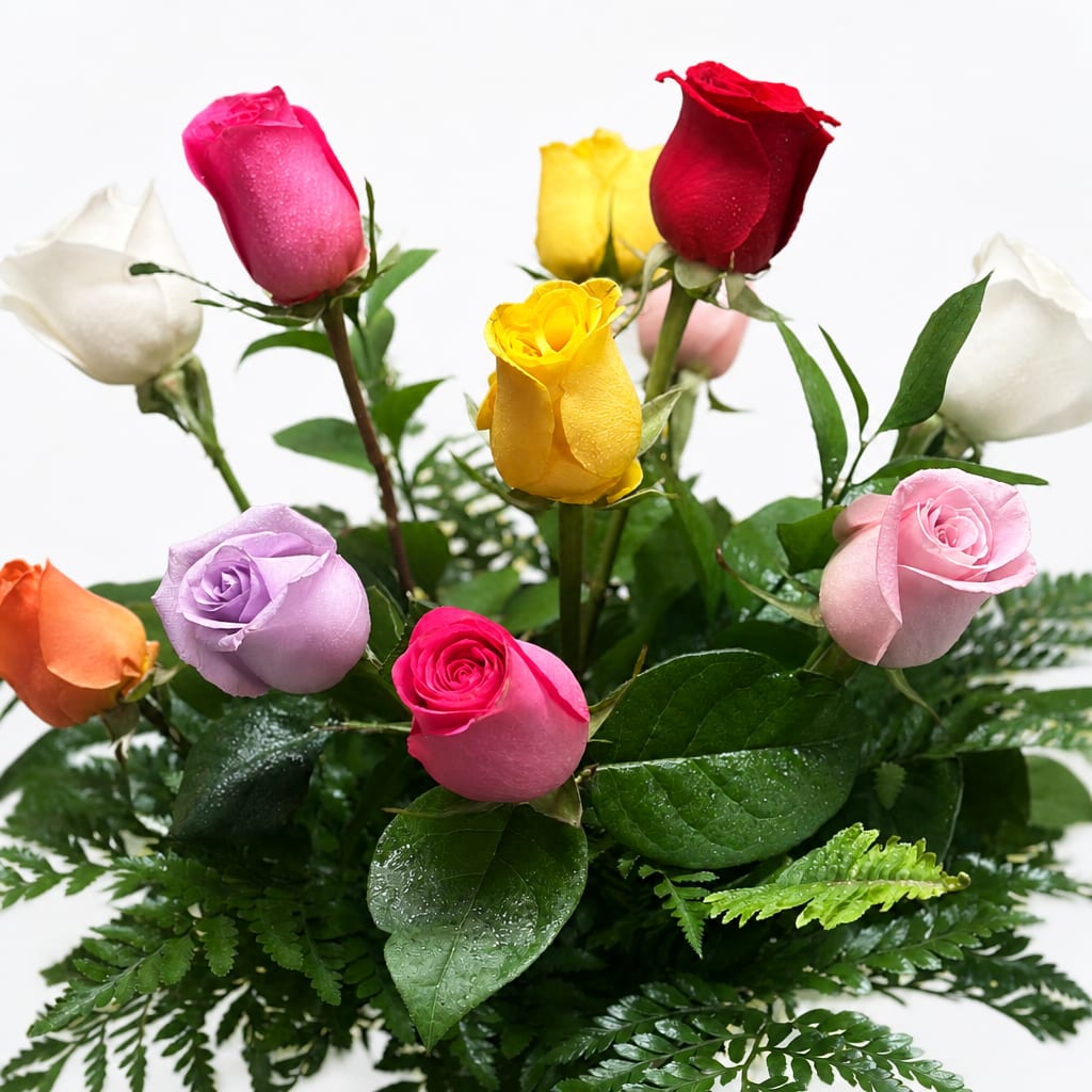 Colorful roses arranged in a low bouquet with fern foliage