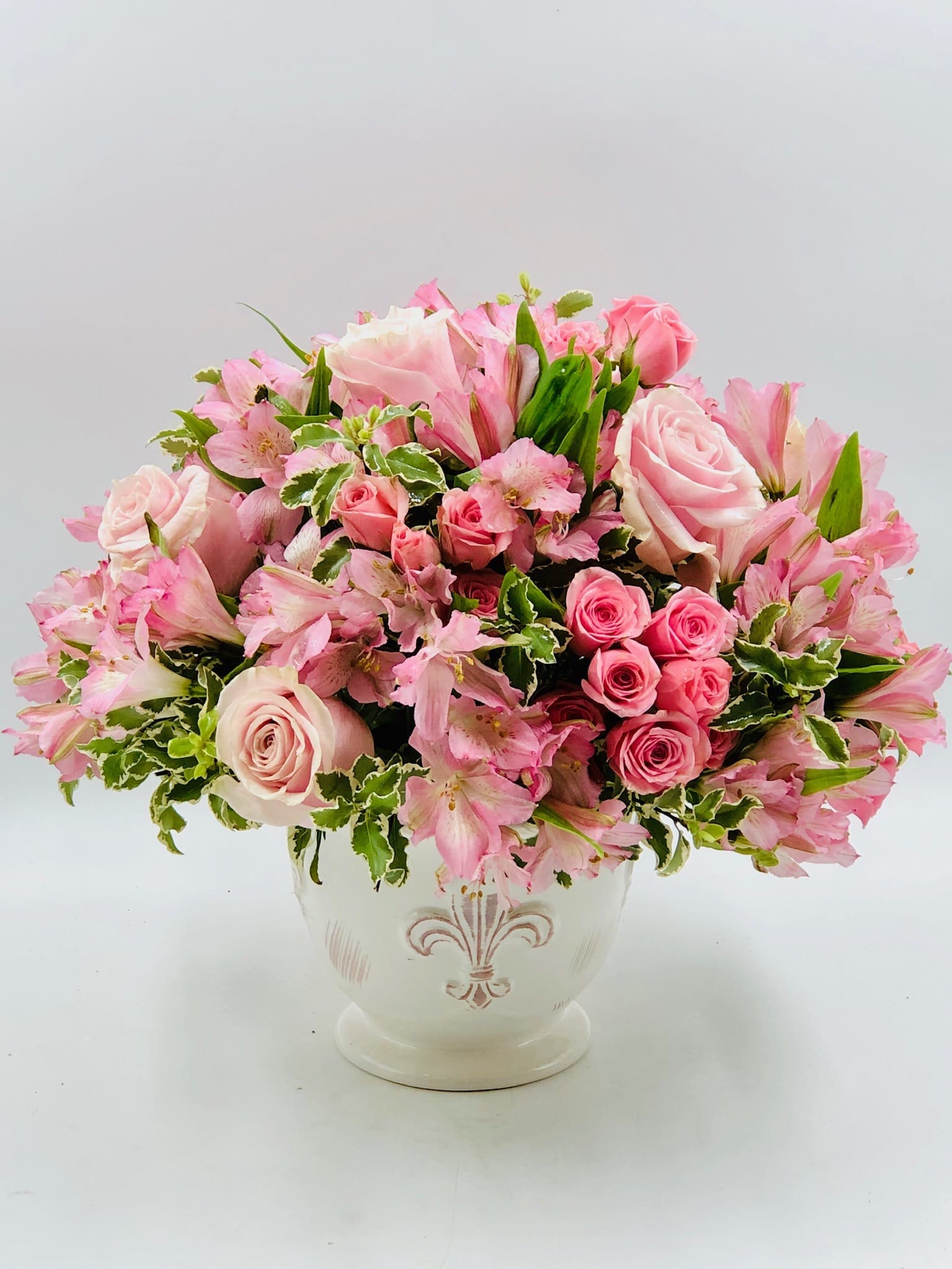Pink roses and alstroemeria arranged in a white vase