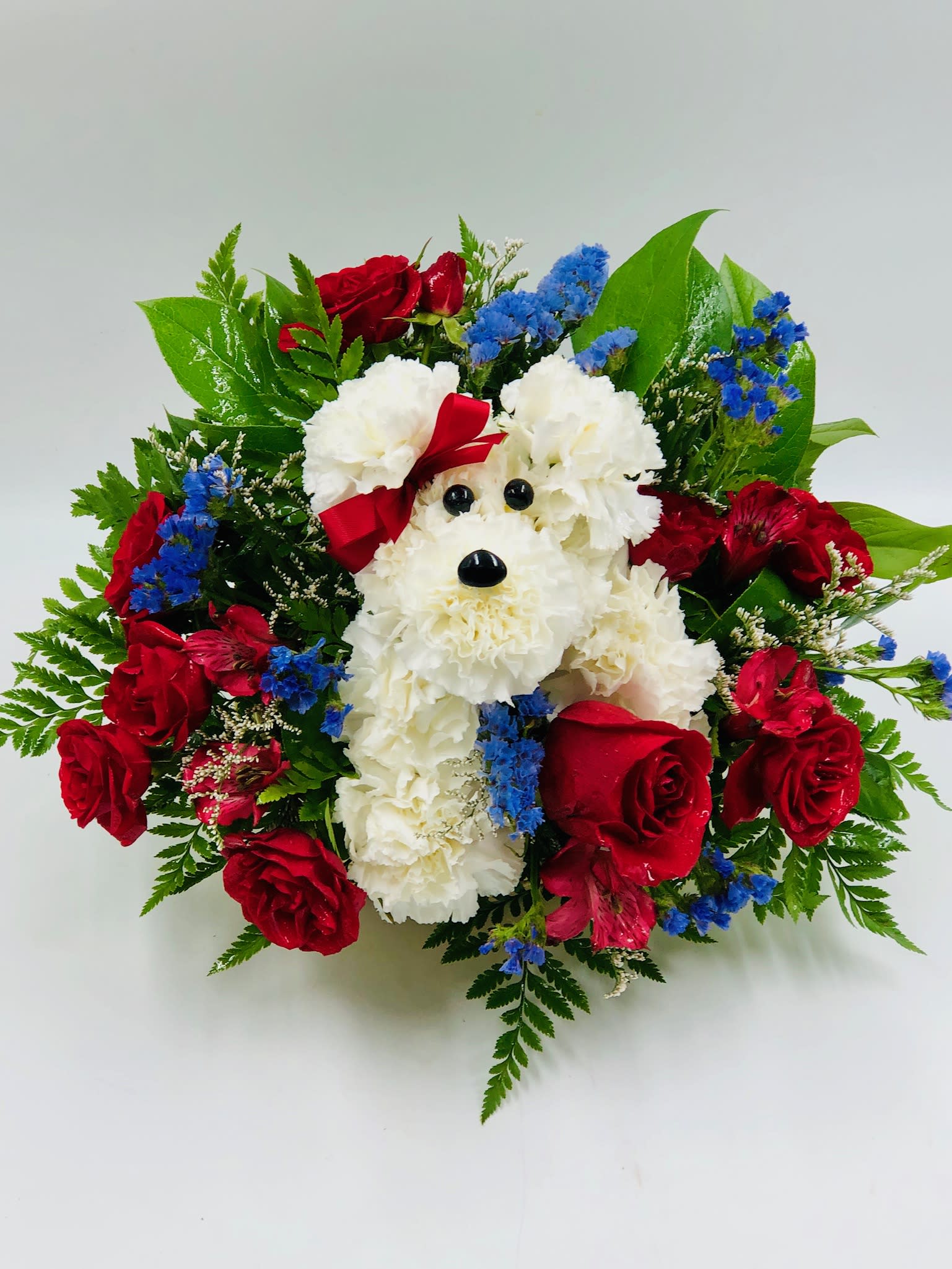 Dog-shaped floral arrangement with red roses and white carnations