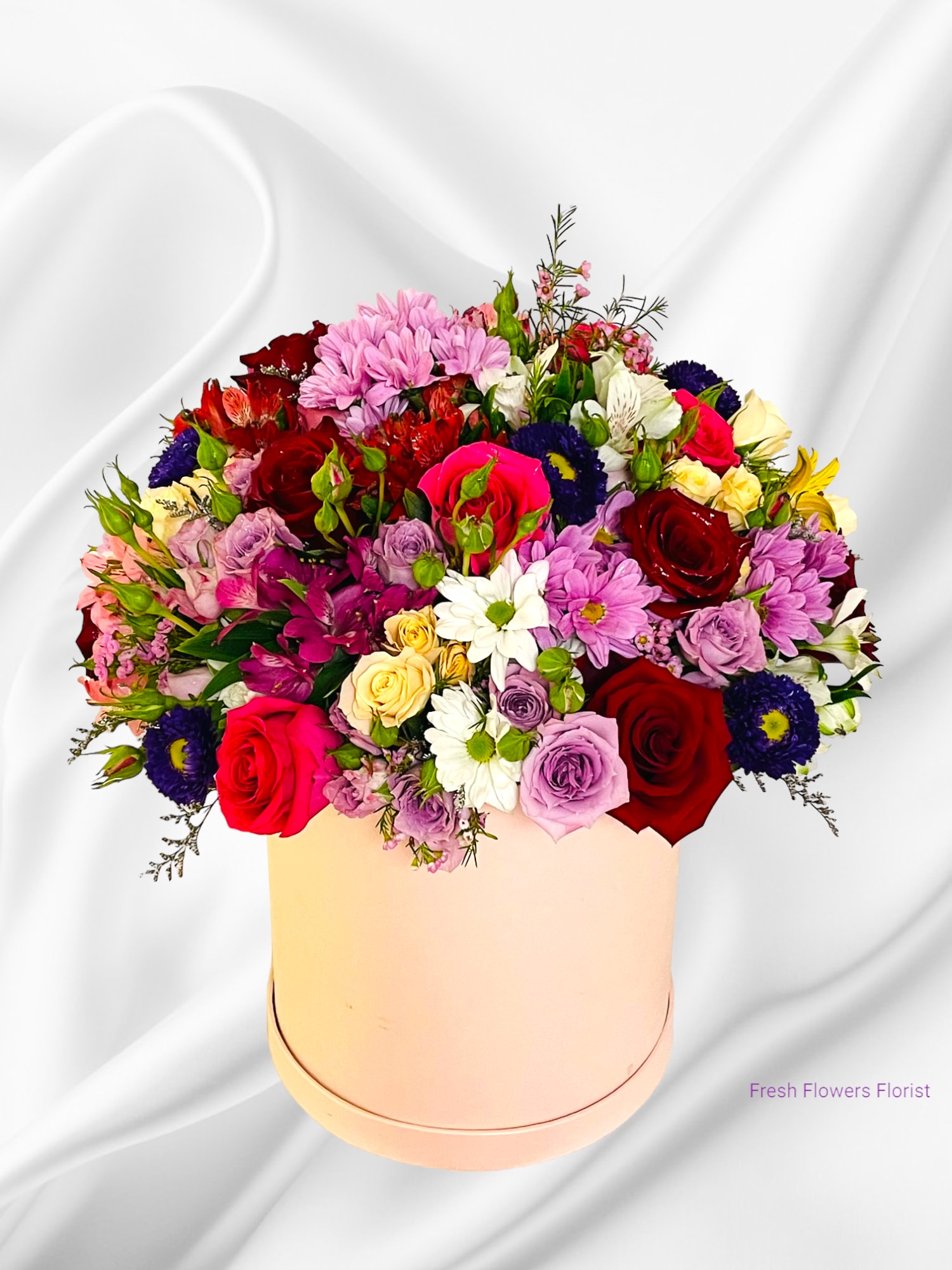 Mixed bouquet of roses, daisies, and alstroemeria in a round box