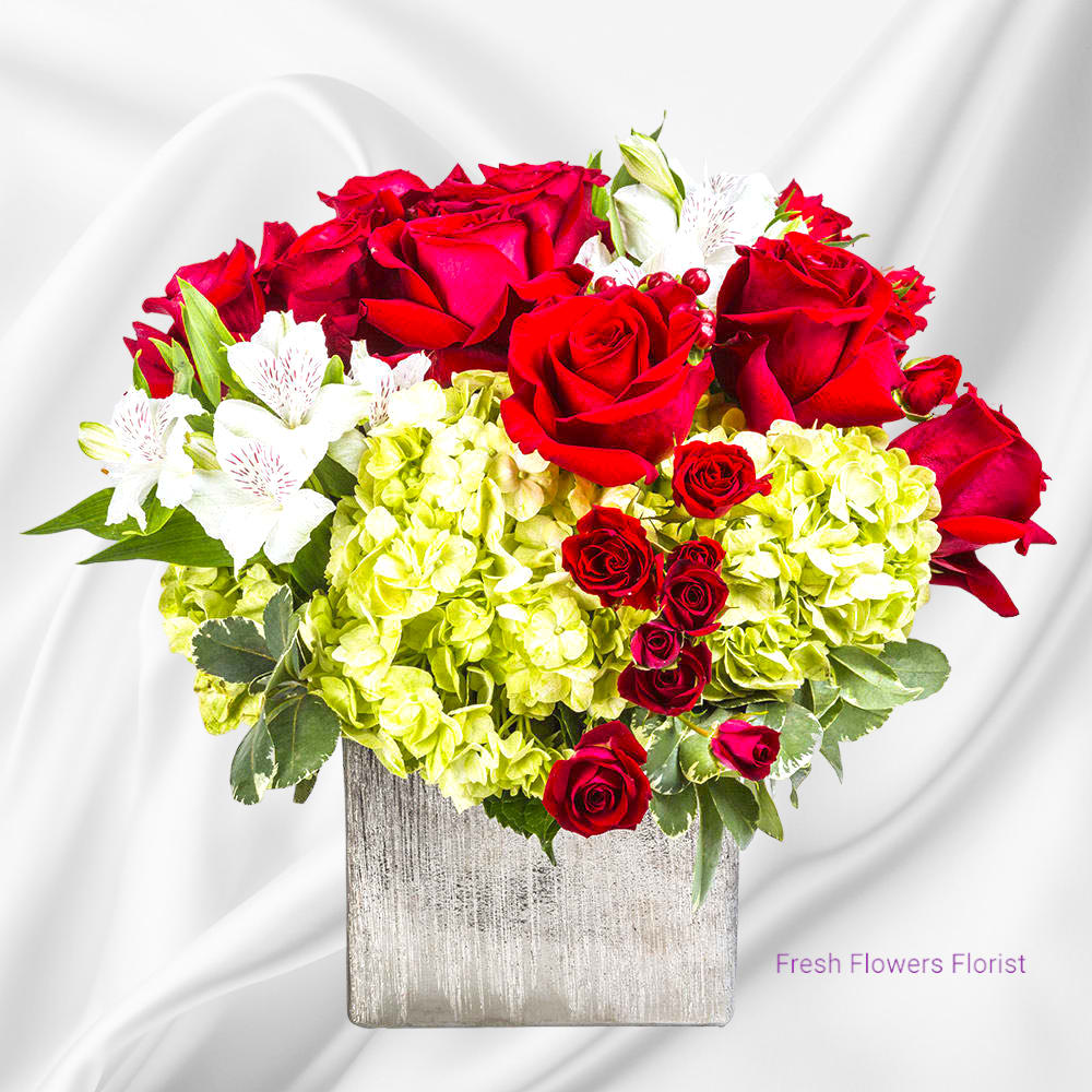Red roses and white alstroemeria in a square silver vase