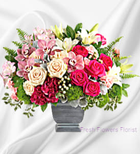 Mixed pink and white flower arrangement in a gray vase