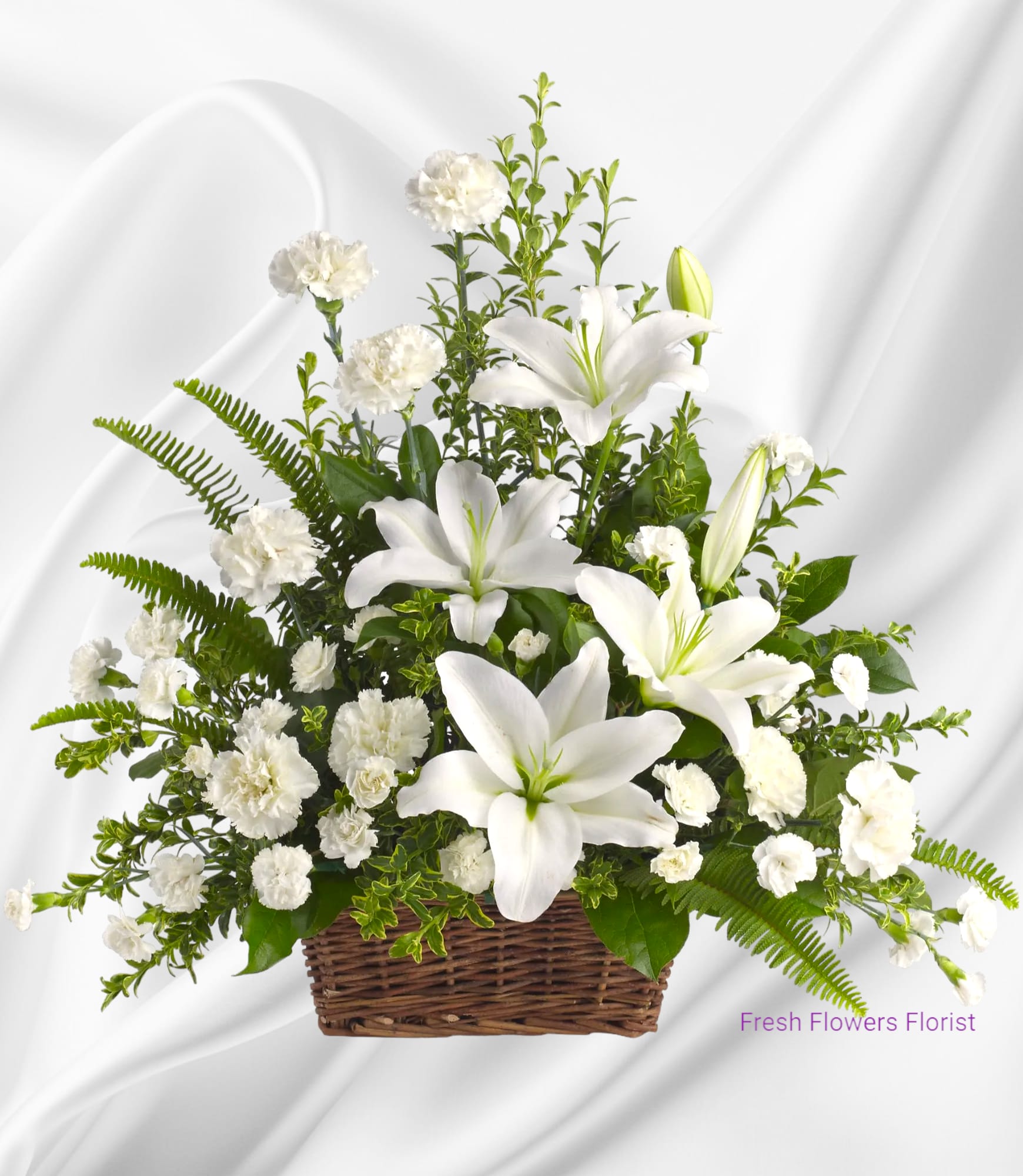 White lilies and carnations arranged in a wicker basket