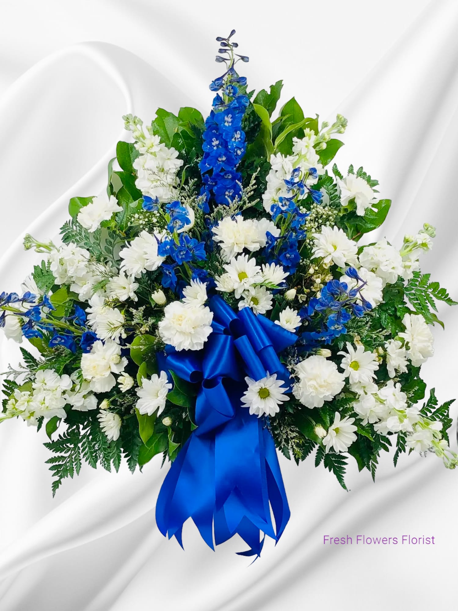 White and blue floral spray with a satin ribbon bow