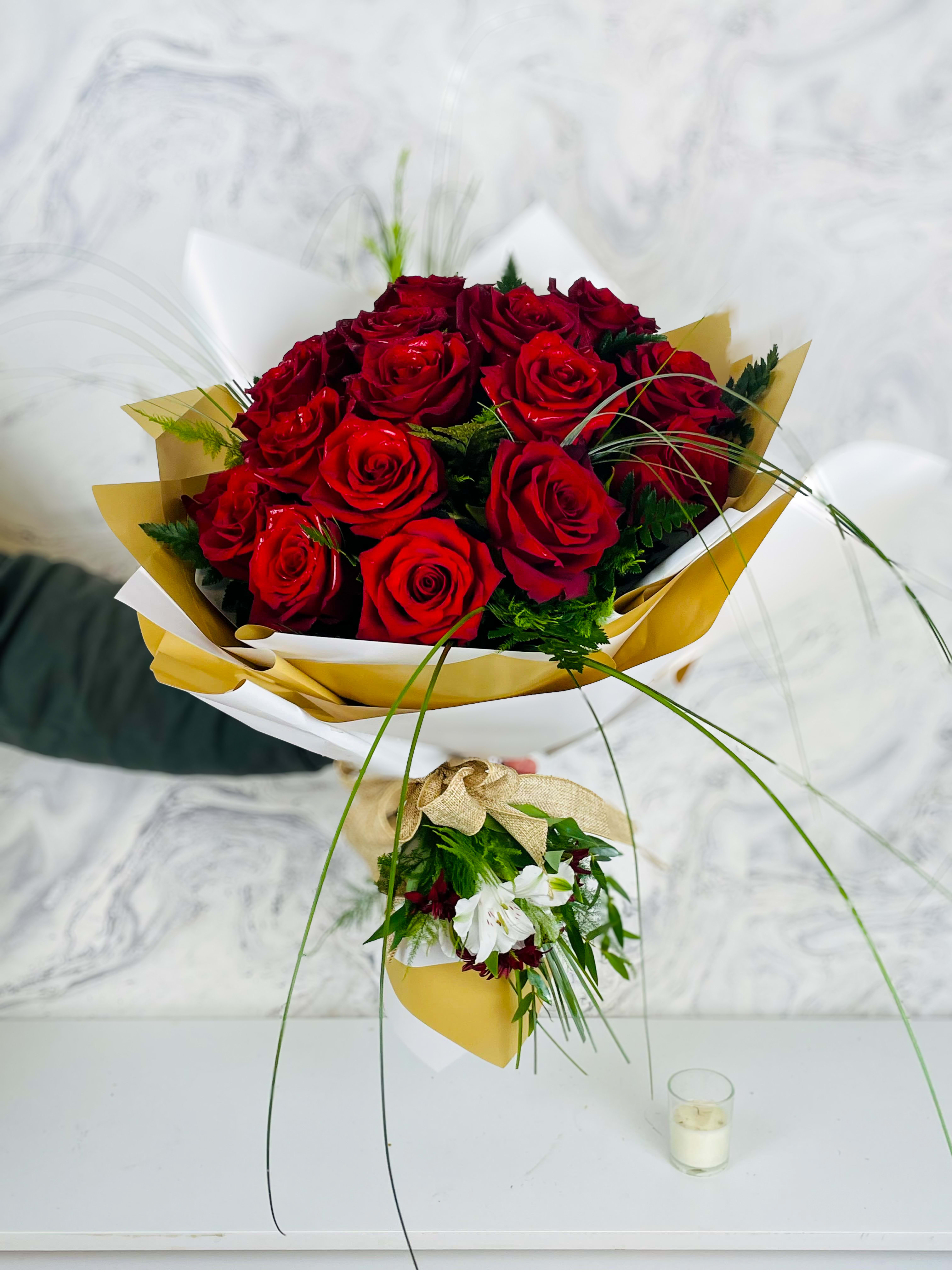 Bouquet of red roses wrapped in white and gold paper