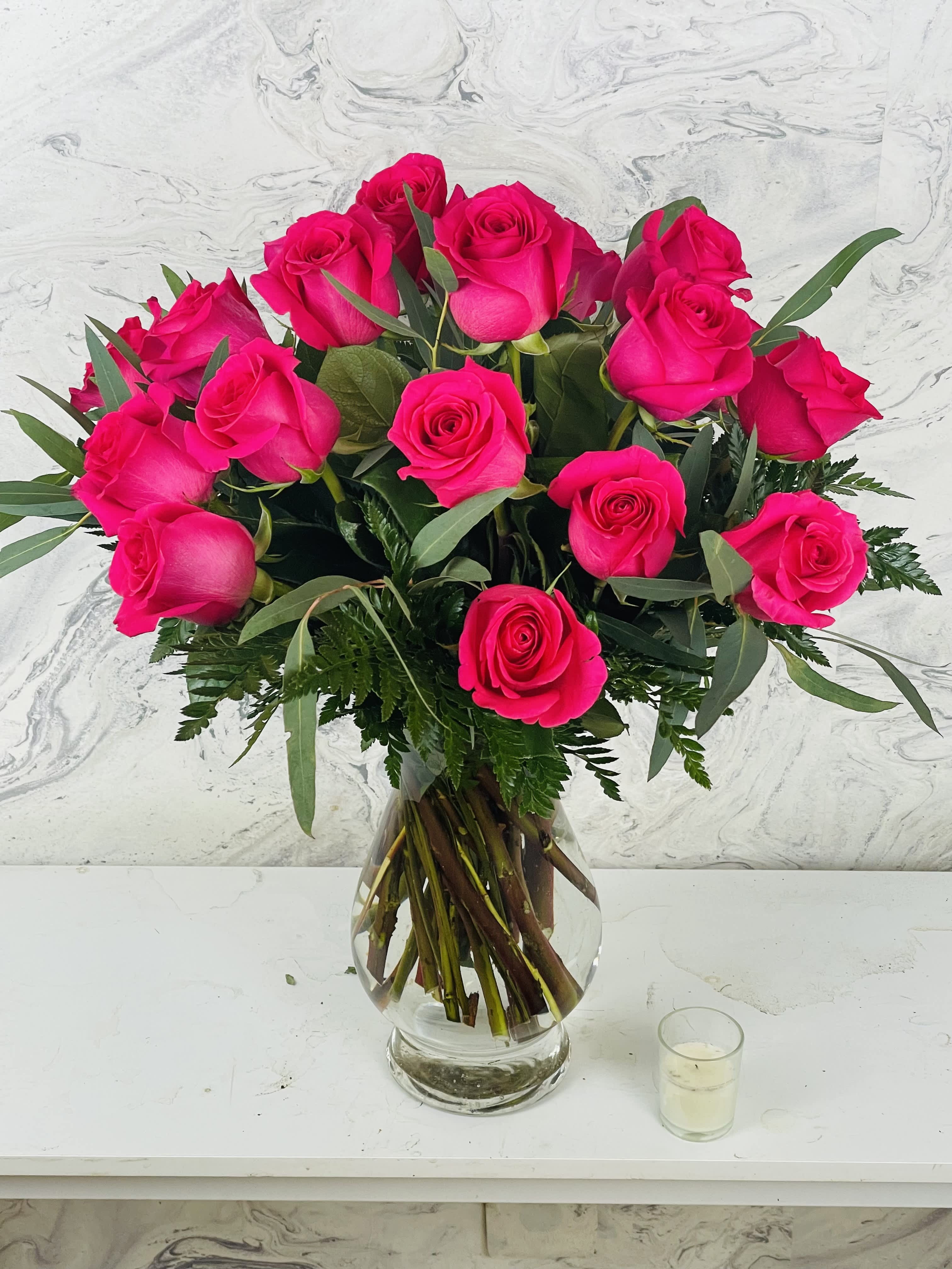 Bouquet of bright pink roses in a clear glass vase
