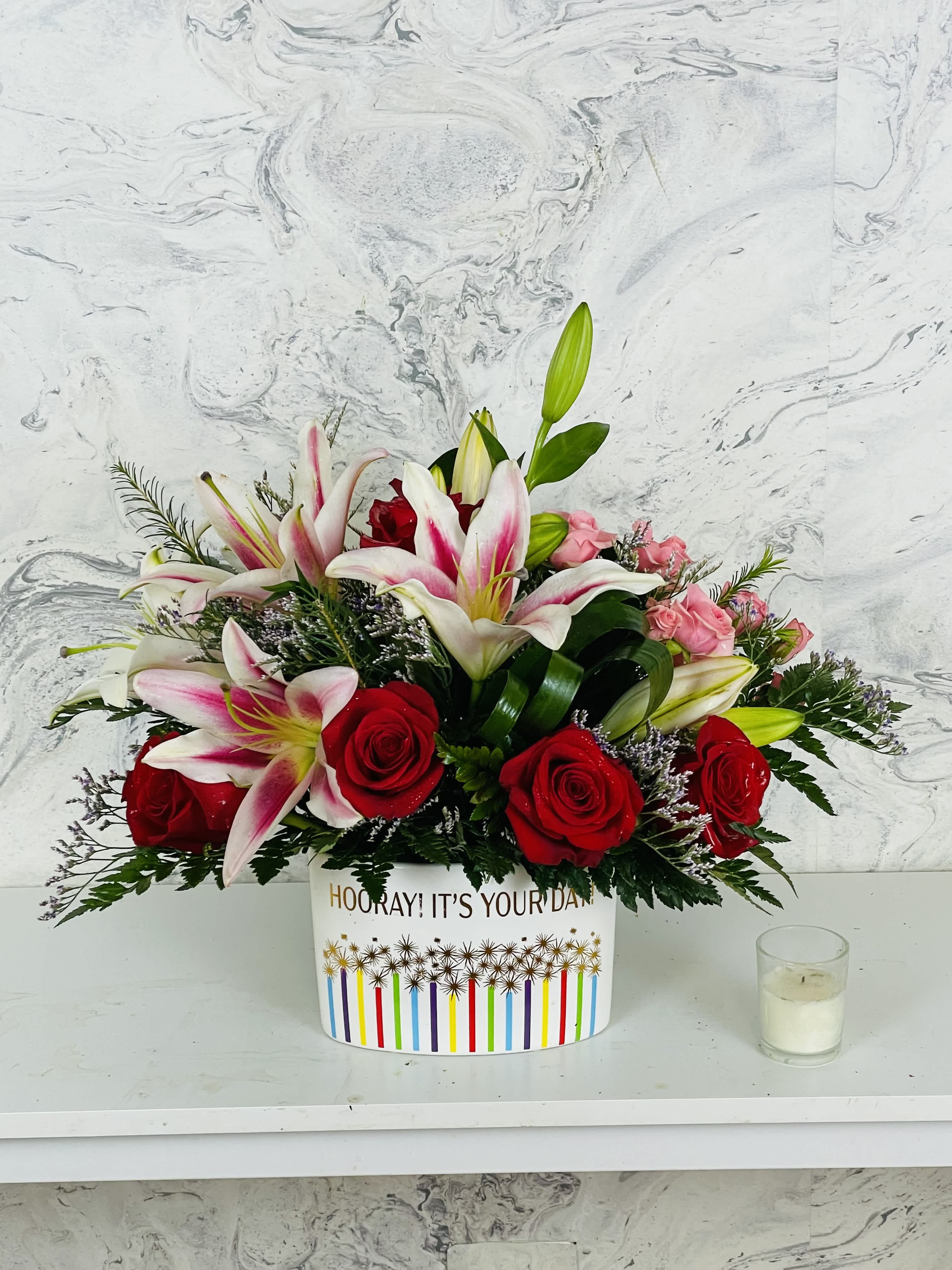 Bouquet of red roses and pink lilies in a decorative box