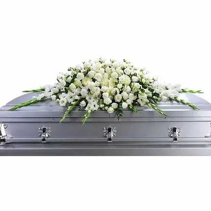 White floral casket spray on a silver casket
