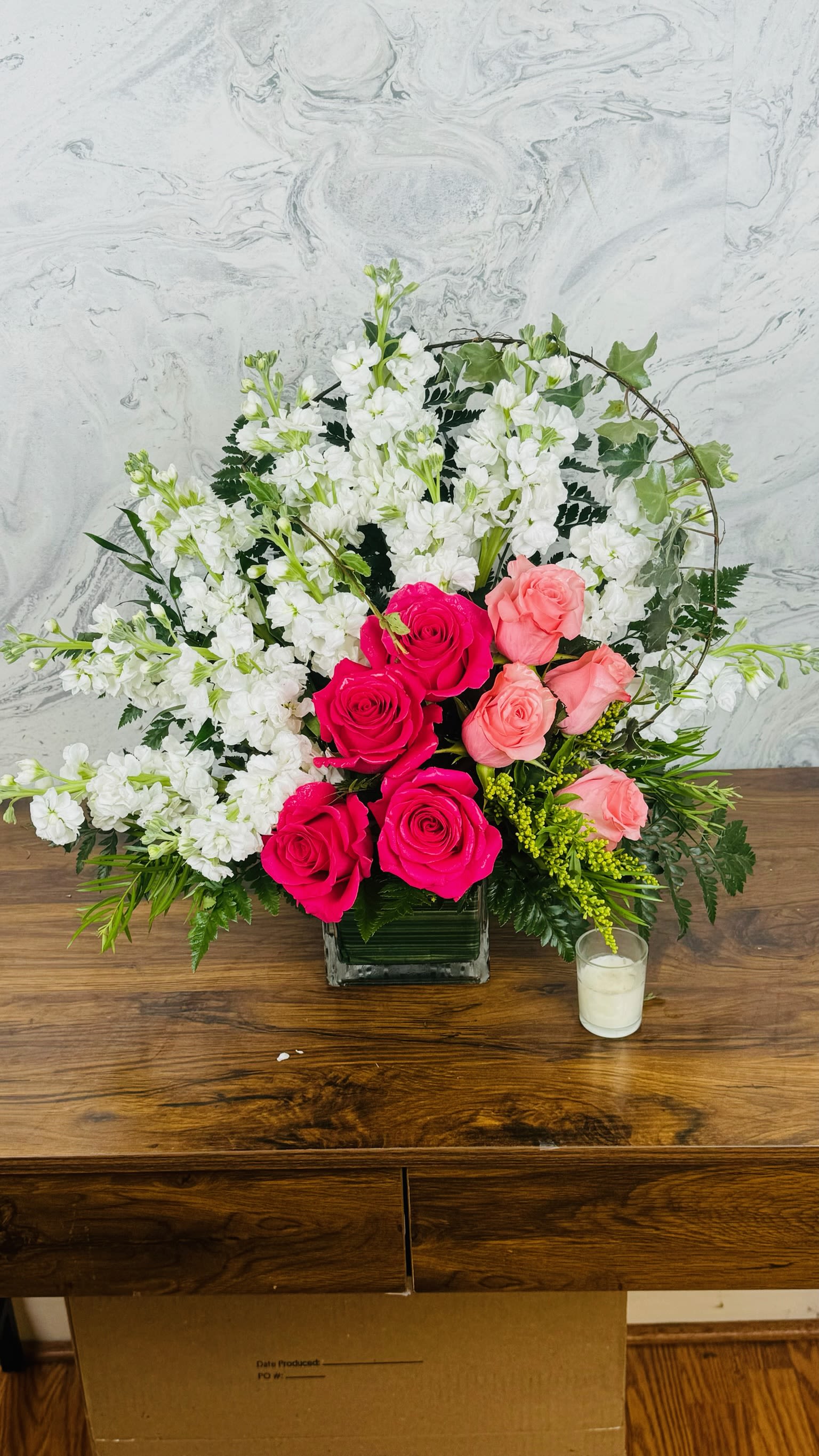Pink and white rose arrangement in a square glass vase