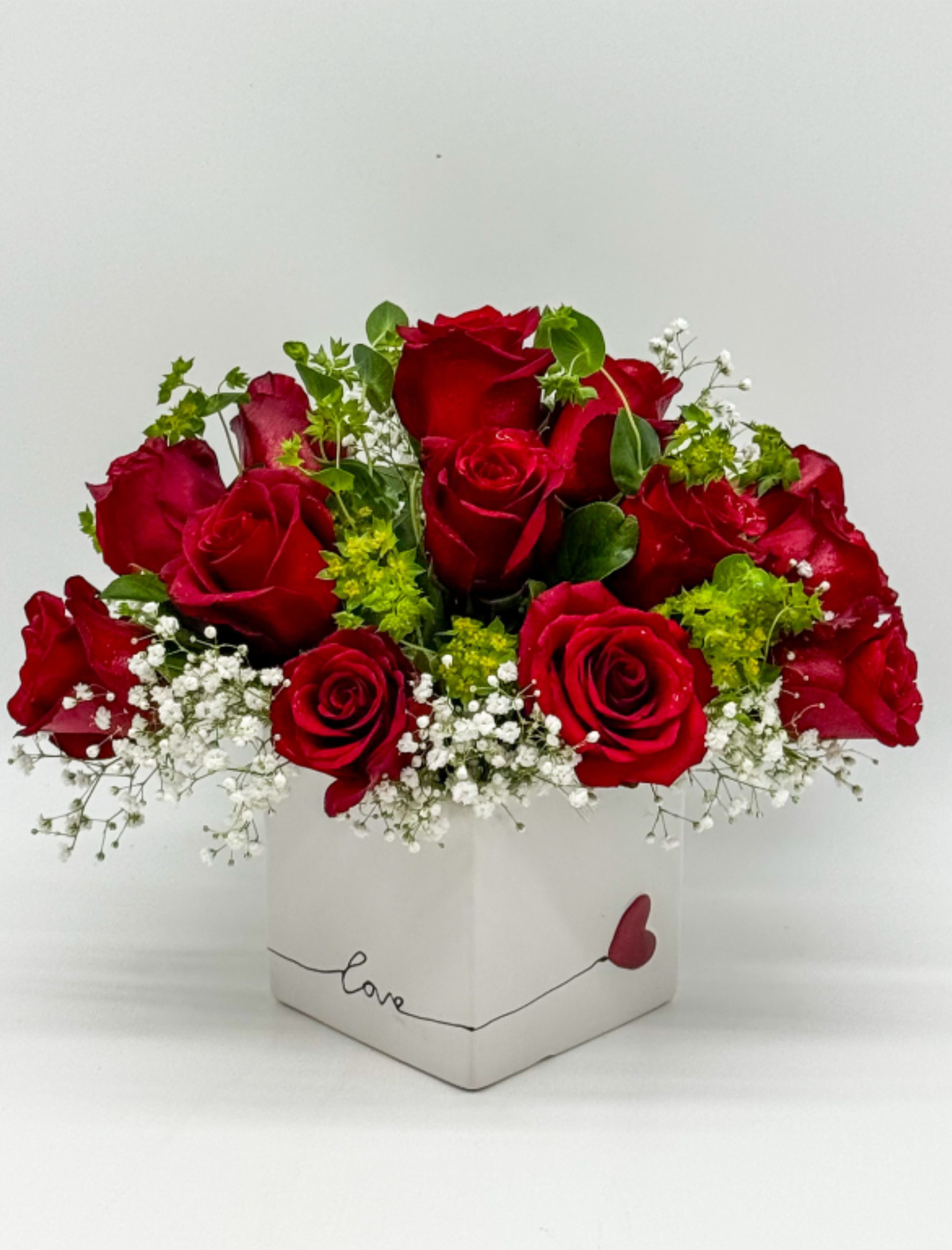 Red roses in a white square box with baby’s breath
