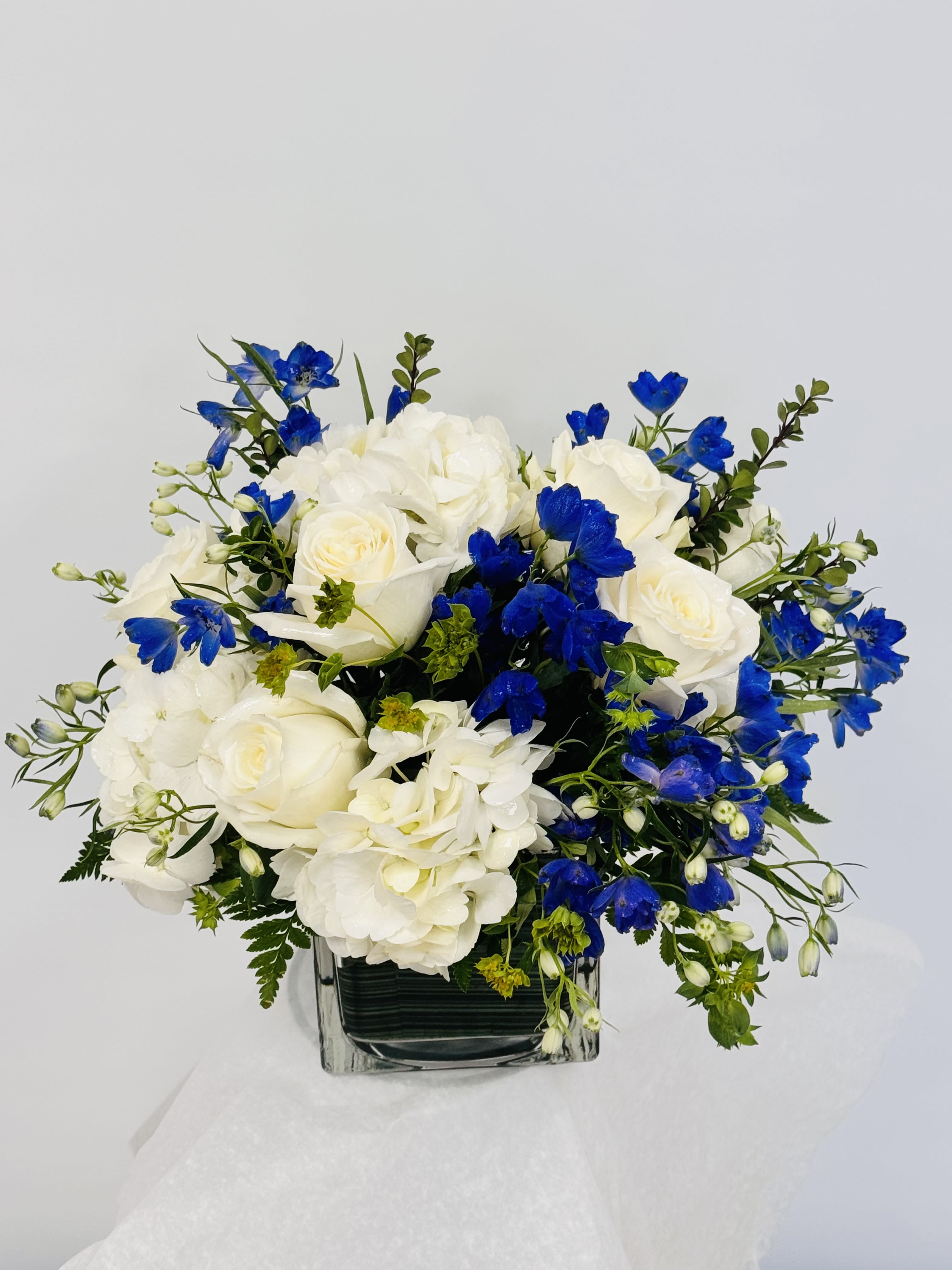 Breath of Fresh Air  - This is the perfect gift for someone who can use some R &amp; R. The arrangement contains roses, carnations, blue iris, and other seasonal blooms. APPROXIMATE DIMENSIONS: 8" L x 8" W x 8" H, .perfect for birthday, Father's Day, get well,  just because, thank you , I'm sorry , Mother's Day,funeral and sympathy 